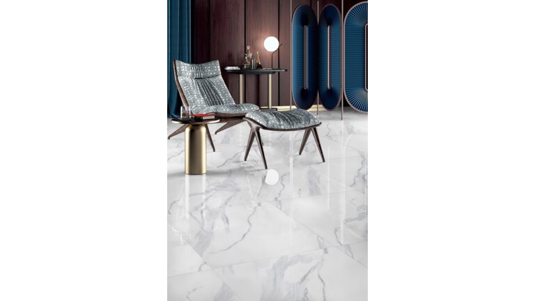 Eleganter Sessel auf glänzenden Fliesen in Marmoroptik.
